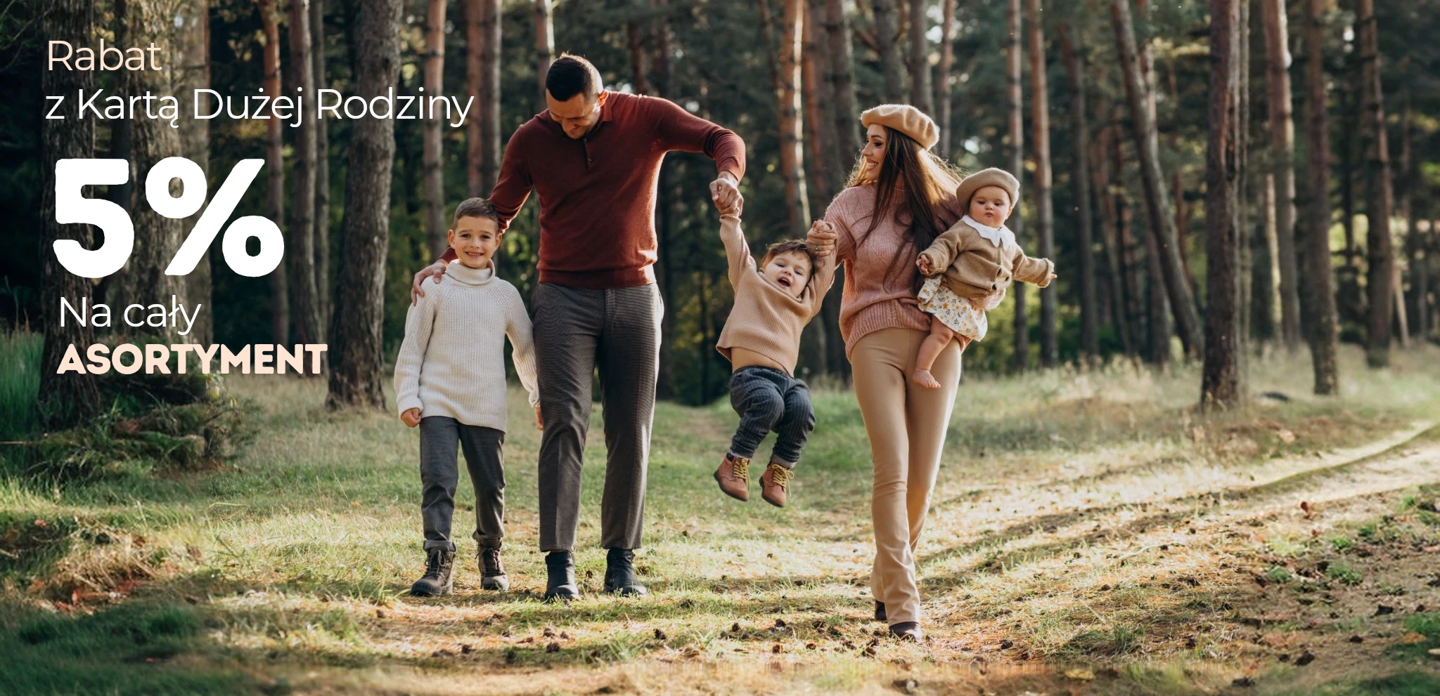 Rodzina na spacerze w lesie i tekst w lewym rogu Rabat z Kartą Dużej Rodziny 5% na cały asortyment