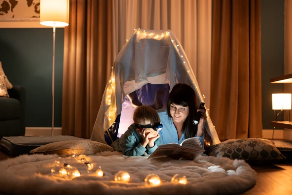 Mama z dzieckiem czytająca książkę w nastrojowym pokoju