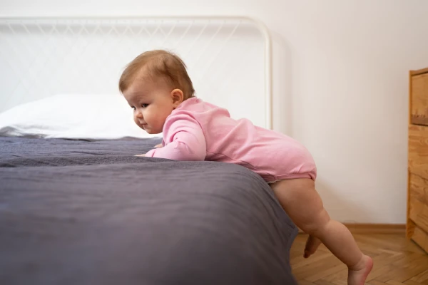 Dziecko wspinające się na łóżko