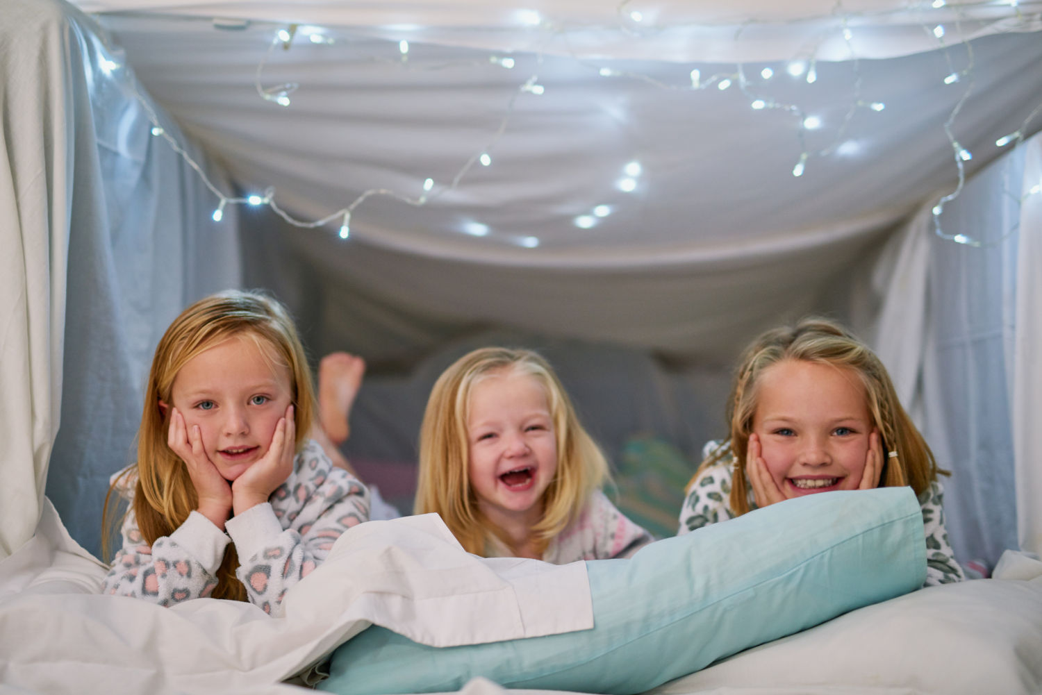 Roześmiane dzieci leżące na łóżku