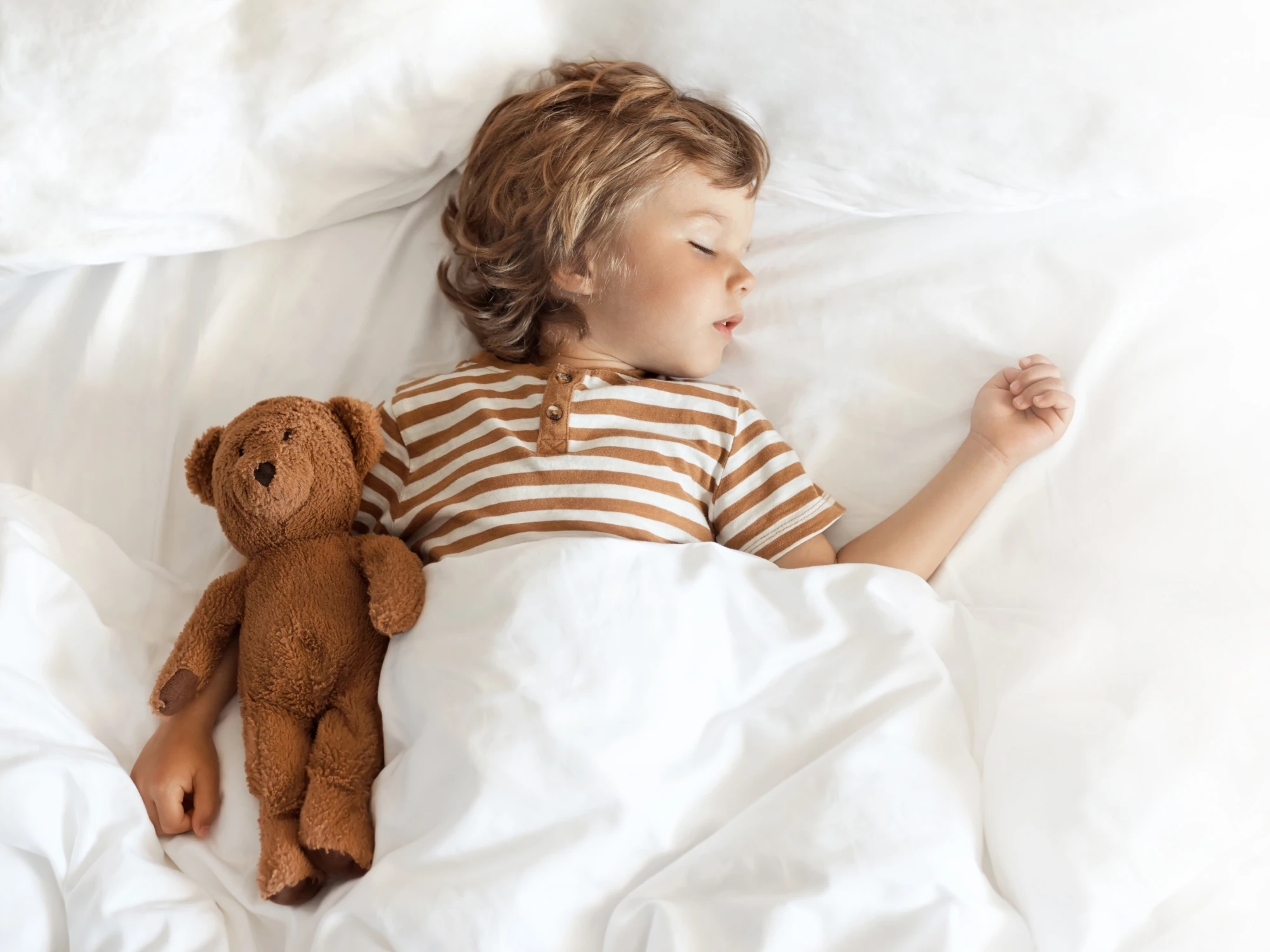 Chłopiec śpiący z misiem